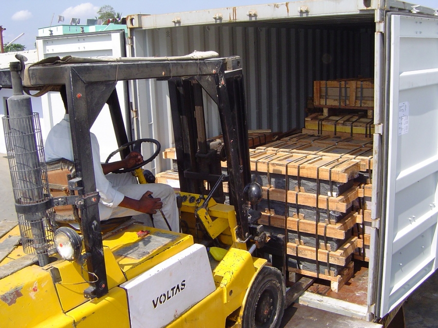 Forklift stuffing wooden crates into container