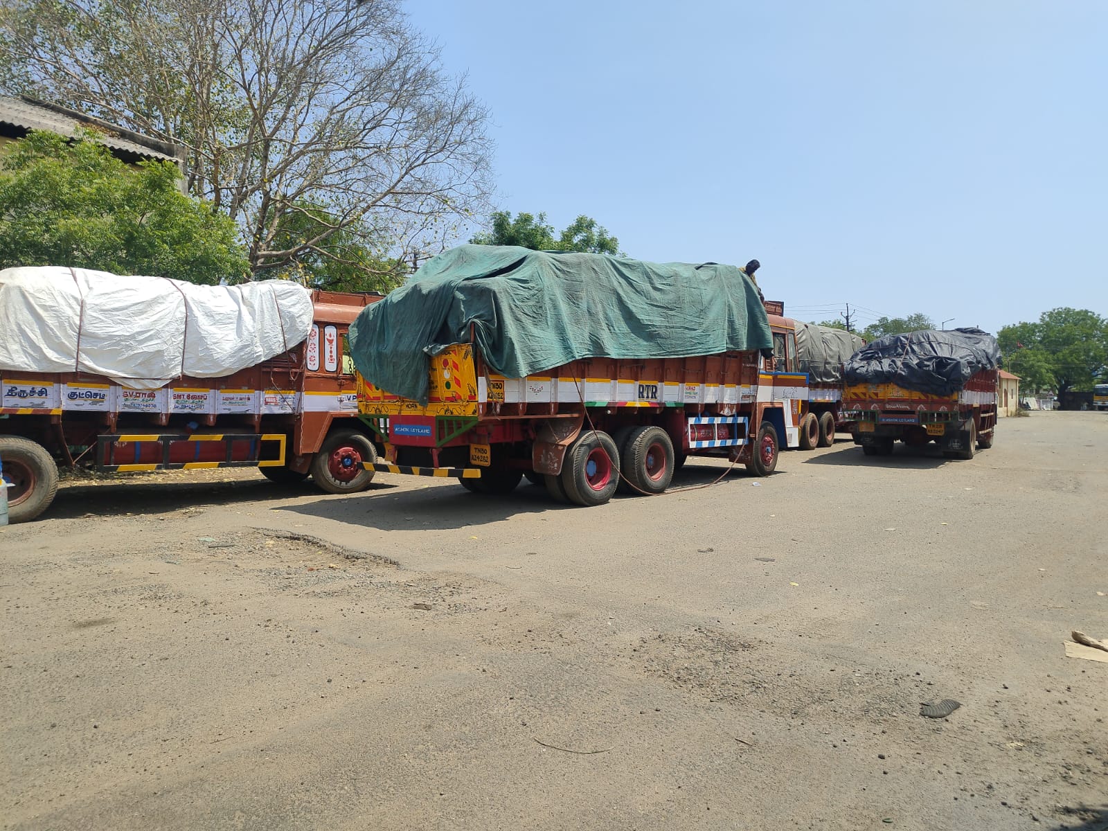 Multiple trucks parked, loaded and covered